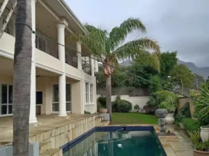 Palm tree next to a big house ready to be trimmed